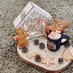 ceppo di legno con casetta natalizia e biscotti pan di zenzero