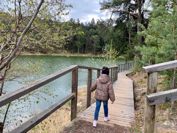bambina che cammina su sentiero in riva al lago